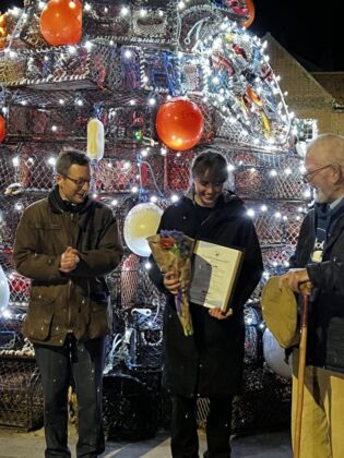 Chelsey receiving her award from Duncan Baker MP (left) watched by The Norfolk Boat founder Andrew Cuthbert